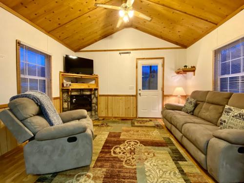 a living room with a couch and a tv at Maggie Valley Cabin Rentals in Maggie Valley