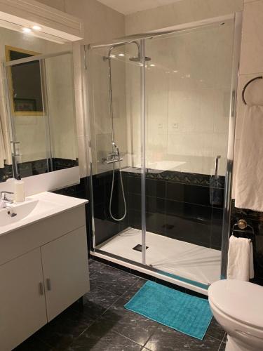 ein Bad mit einer Dusche, einem Waschbecken und einem WC in der Unterkunft GranVia Fira Apartment in Hospitalet de Llobregat