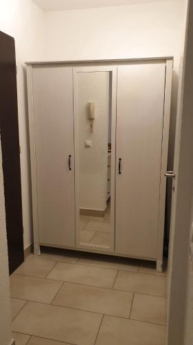 a bathroom with two white doors and a tile floor at Workers-Sleep-Station in Cologne
