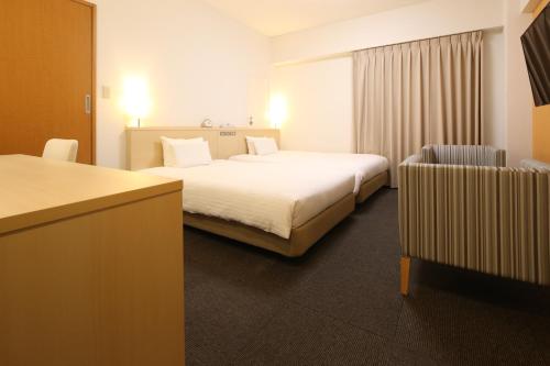 a hotel room with a bed and a chair at AB Hotel Mikawa Anjo Honkan in Anjo