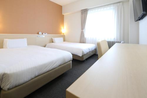 a hotel room with two beds and a window at AB Hotel Mikawa Anjo Honkan in Anjo