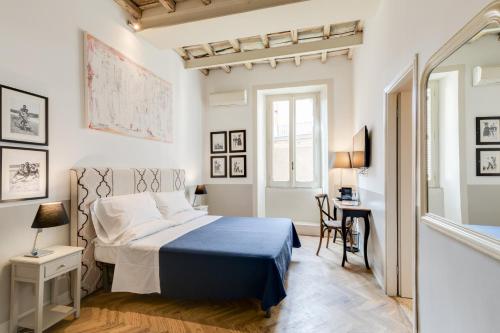 a white bedroom with a bed and a desk at The Bluehostel in Rome