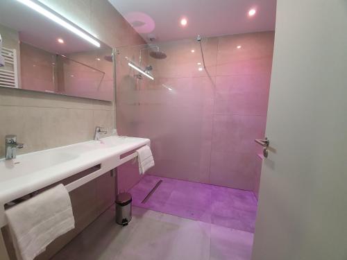 y baño con lavabo y ducha. en Berg'hotel en Socx