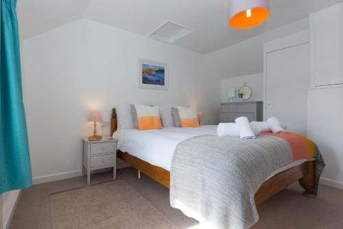 1 dormitorio con 1 cama grande con almohadas de color naranja y blanco en 85 Back Road East en St Ives