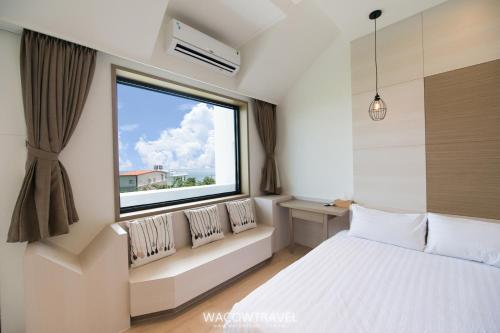 a bedroom with a bed and a large window at 懶人旅宿 in Xiaoliuqiu