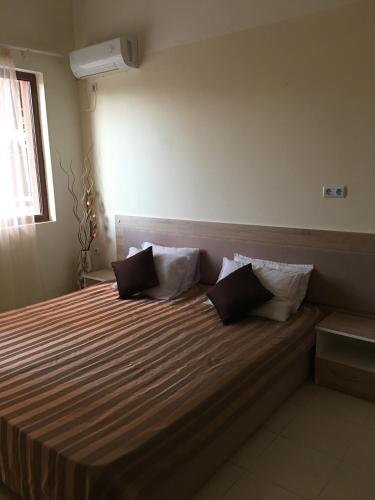a bedroom with a bed with two pillows on it at Apart Hotel salt Lake in Pomorie