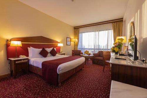 a hotel room with a large bed and a desk at Golden Tulip Hotel Flamenco Cairo in Cairo