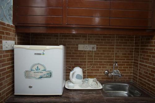 a kitchen with a sink and a small refrigerator at Hotel Vista Bay in Cox's Bazar
