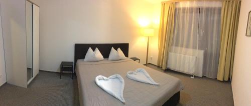 a hotel room with a bed with two heart shaped towels at Ski Vital Apartments in Sankt Michael im Lungau