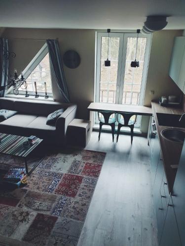 a living room with a couch and a table at Amber Ambient Apartments in Juodkrantė