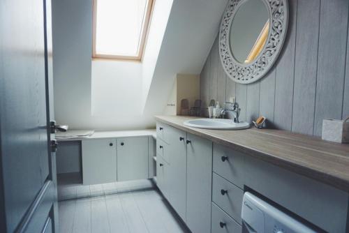 a bathroom with a sink and a mirror on the wall at Amber Ambient Apartments in Juodkrantė