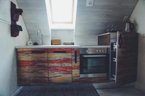 a kitchen with a stove and a refrigerator at Amber Ambient Apartments in Juodkrantė