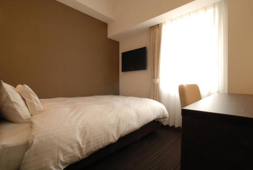 a hotel room with a bed and a window at AB Hotel Nagoya Sakae in Nagoya