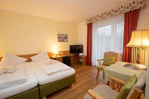 a hotel room with two beds and a television at Landhotel Agathawirt in Bad Goisern