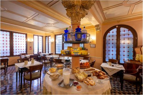 uma sala de jantar com uma mesa com comida em Hotel Marconi em Veneza
