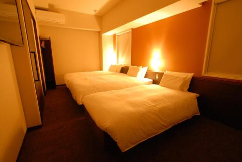 a hotel room with two beds and a window at AB Hotel Toyohashi in Toyohashi
