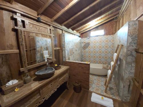 a bathroom with a sink and a bath tub at Kirani Joglo Villa Bali by Mahaputra in Sukawati
