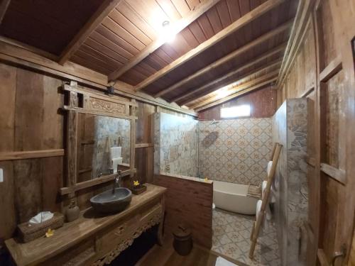 a bathroom with a sink and a bath tub at Kirani Joglo Villa Bali by Mahaputra in Sukawati