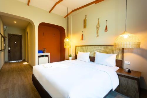 a bedroom with a large white bed in a room at BARA BARA' Budget SATUN 'SHA Plus' in Satun