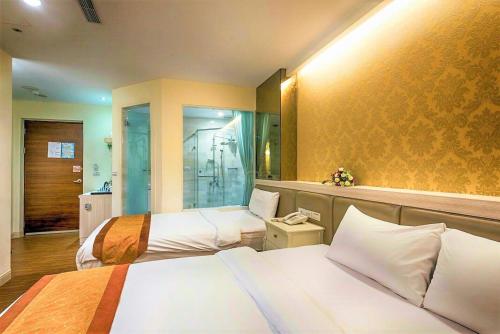 a hotel room with two beds and a shower at Taitung Z. Hotel in Taitung City