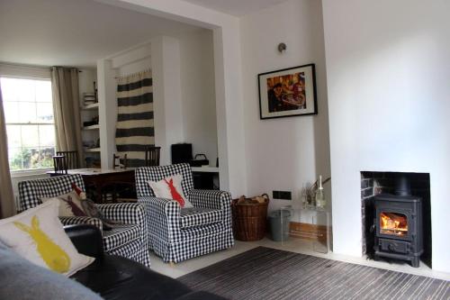 a living room with two chairs and a fireplace at Guillemot in Beaumaris