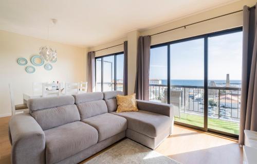 a living room with a couch and a view of the ocean at House at the Sea (city historial center with sea view) in Ponta Delgada