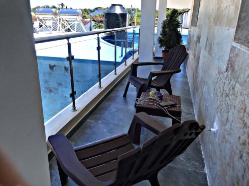 2 sillas y una mesa en un balcón con piscina en Charming 1b Apto Walk To The Beaches & Main Street, en Sosúa