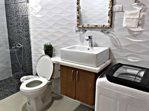 a bathroom with a white toilet and a sink at Charming 1b Apto Walk To The Beaches & Main Street in Sosúa