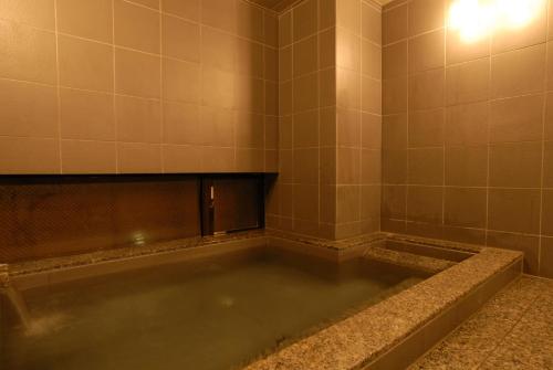 un baño vacío con una bañera llena de agua en AB Hotel Isesaki en Isesaki