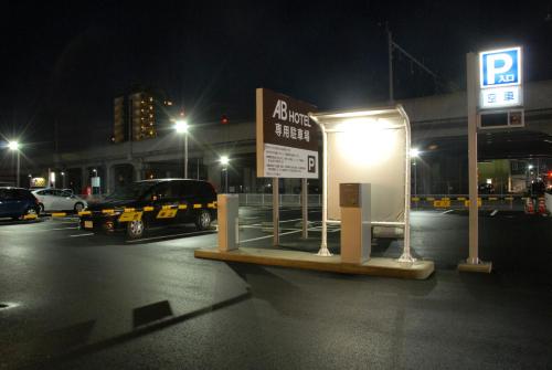 a parking lot at night with a parking sign at AB Hotel Isesaki in Isesaki