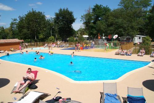 un groupe de personnes dans une piscine dans l'établissement CAMPING LES OURMES, à Hourtin