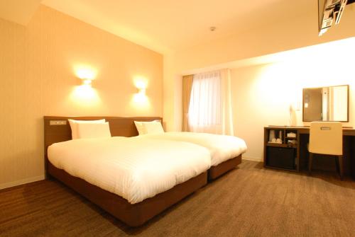 una camera d'albergo con un letto e una televisione di AB Hotel Mikawa Toyota a Toyota