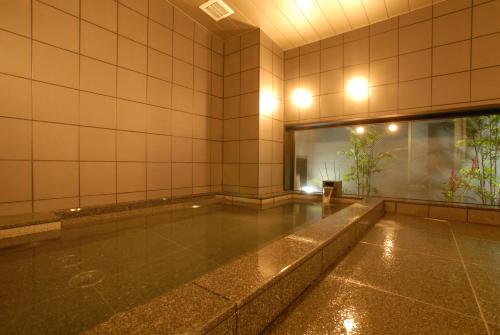 an empty swimming pool in a room with a window at AB Hotel Mikawa Toyota in Toyota