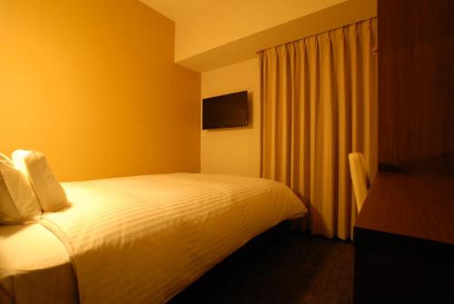 a hotel room with a bed and a television at AB Hotel Gifu in Gifu