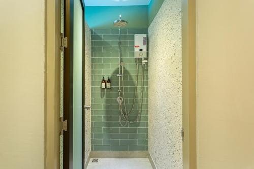 a bathroom with a shower with green tiles at BARA BARA' Budget SATUN 'SHA Plus' in Satun