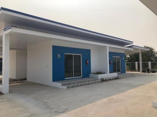 a blue and white building with a parking lot at SiRi Resort in Maha Sarakham