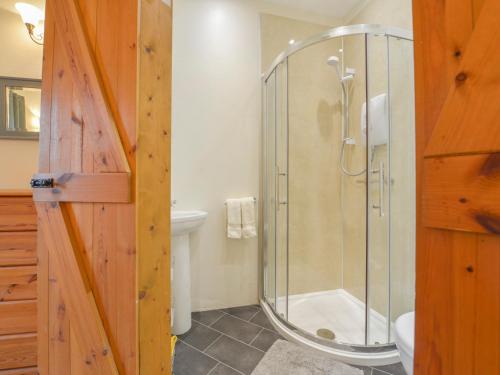 a bathroom with a shower with a glass door at Miners Dry in Gunnislake