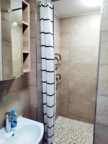 a bathroom with a shower curtain and a sink at Trumpalaikė nuoma centre in Šiauliai