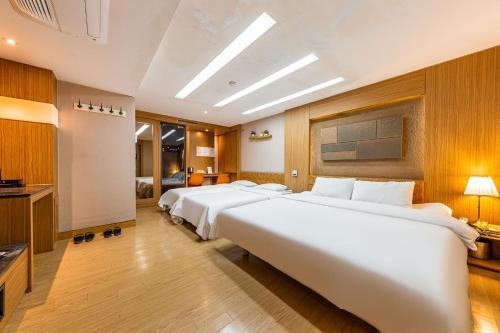 a row of beds in a hotel room at Friendly DH Naissance Hotel by Mindrum Group in Seoul
