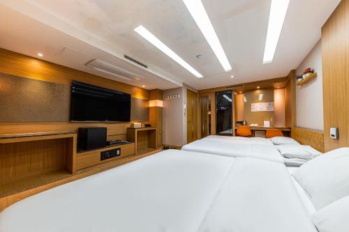 a hotel room with two beds and a flat screen tv at Friendly DH Naissance Hotel by Mindrum Group in Seoul