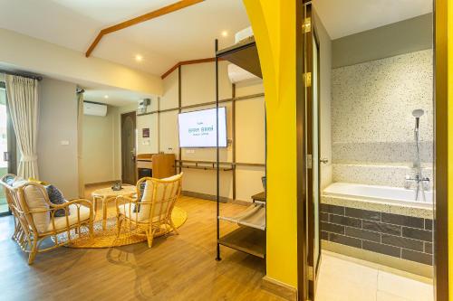 a bathroom with a tub and a table and chairs at BARA BARA' Budget SATUN 'SHA Plus' in Satun