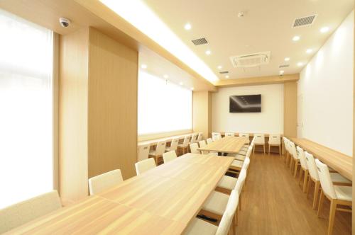 an empty lecture room with wooden tables and chairs at AB Hotel Omihachiman in Omihachiman