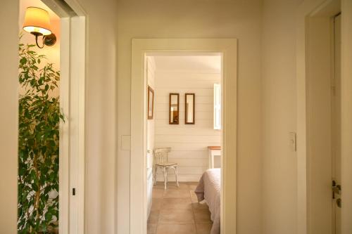a hallway leading to a room with a bed and a table at Casa Nueva Zelanda in Tandil