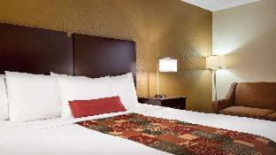 a hotel room with a large bed with a red pillow at Spark By Hilton Williamsburg Historic Area in Williamsburg