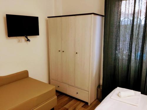 a bedroom with a bed and a cabinet with a television at Pigneto Guest House in Rome