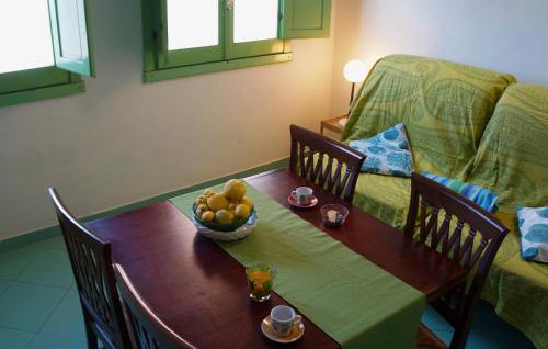 a table with a bowl of fruit and a couch at Castelletto Verde in Bari Sardo