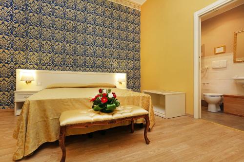 a bedroom with a bed with a flower arrangement on a bench at DG Prestige Room in Rome