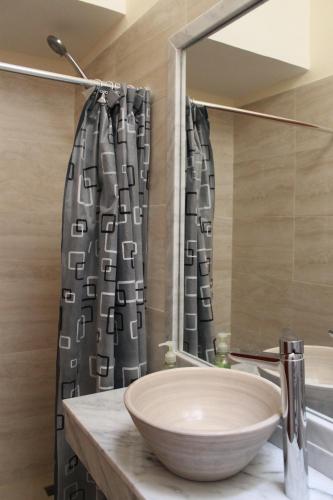 a bathroom with a sink and a shower curtain at Departamentos Virgen del Cerro in Salta
