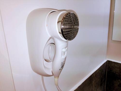 a white hairdryer hanging on a wall at Pigneto Guest House in Rome