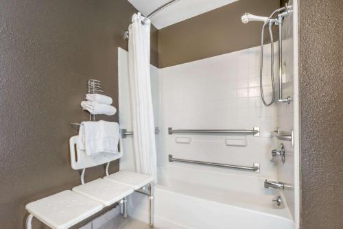 a bathroom with a tub and a shower with towels at Super 8 by Wyndham Georgetown in Georgetown